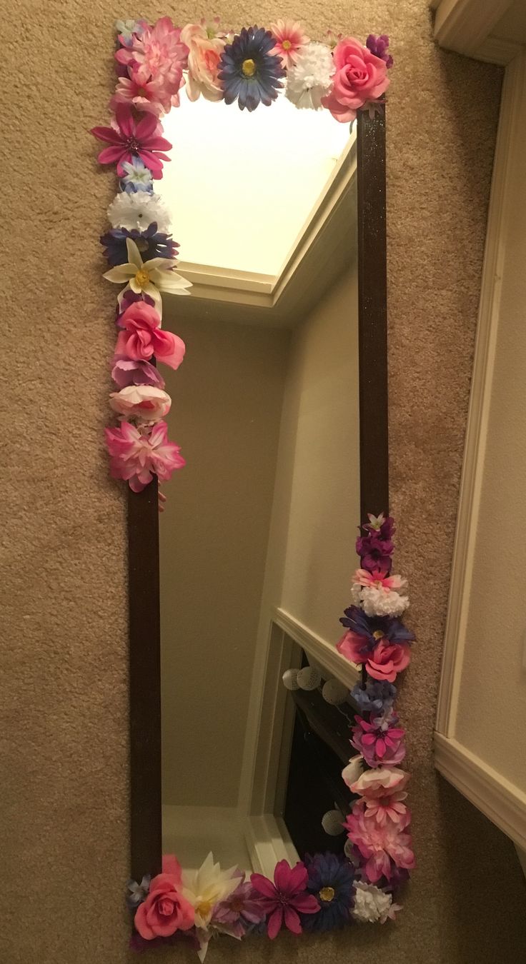 there is a mirror with flowers on it and the bottom half has been made out of paper