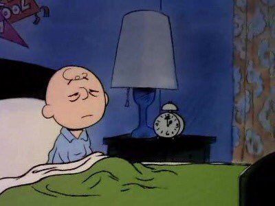 a cartoon character is sleeping in bed with an alarm clock on the nightstand next to him