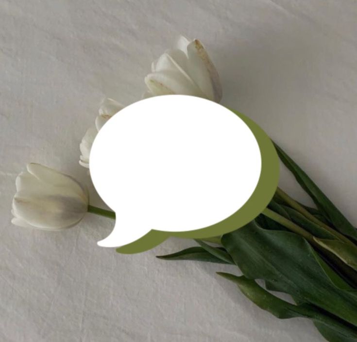 there is a white flower with a green speech bubble on it's side, sitting on a table