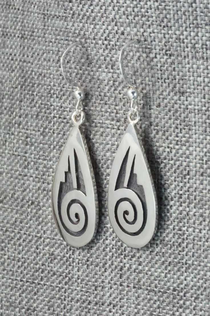 These sterling silver earrings are made by Hopi silversmith Timothy Mowa. The backs are signed and stamped sterling.Length: 1 5/8"Width: 1/2"Free shipping on all orders! We ship with USPS and always include tracking. All orders ship within a day of payment.Returns are accepted up to 30 days after you receive your order. Just send us a message. Our shop offers cash back or store credit. The item must be returned in new condition. Silver Engraved Teardrop Earrings, Engraved Teardrop Sterling Silver Earrings, White Sterling Silver Earrings Stamped 925, Symbolic Sterling Silver Pierced Earrings, Silver Southwestern Style Earrings For Gifting, Southwestern Silver Teardrop Earrings, Silver Southwestern Earrings For Gift, Southwestern Teardrop Sterling Silver Earrings, Silver Southwestern Style Earrings For Gift