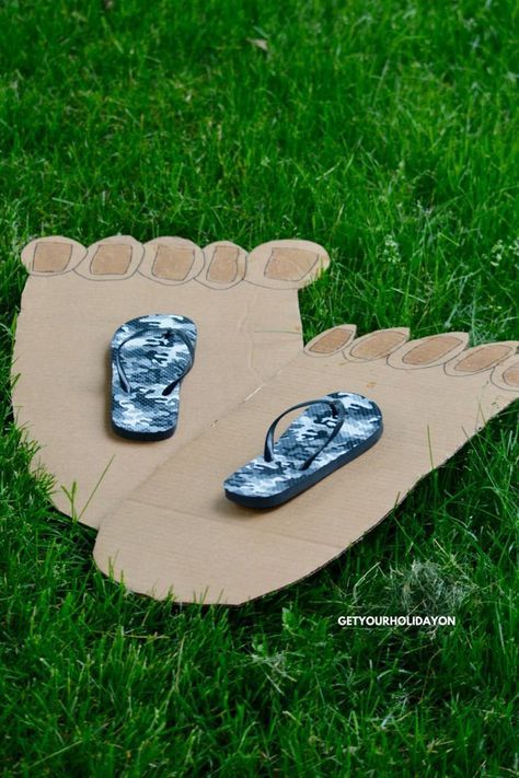 two pairs of flip flops are placed on top of a cardboard board in the grass