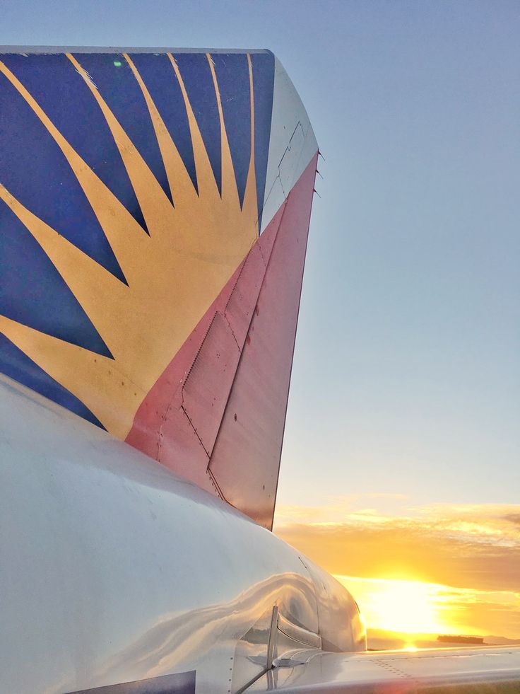 the tail end of an airplane at sunset