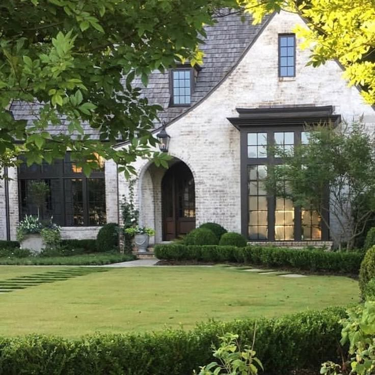 a large house with hedges in front of it