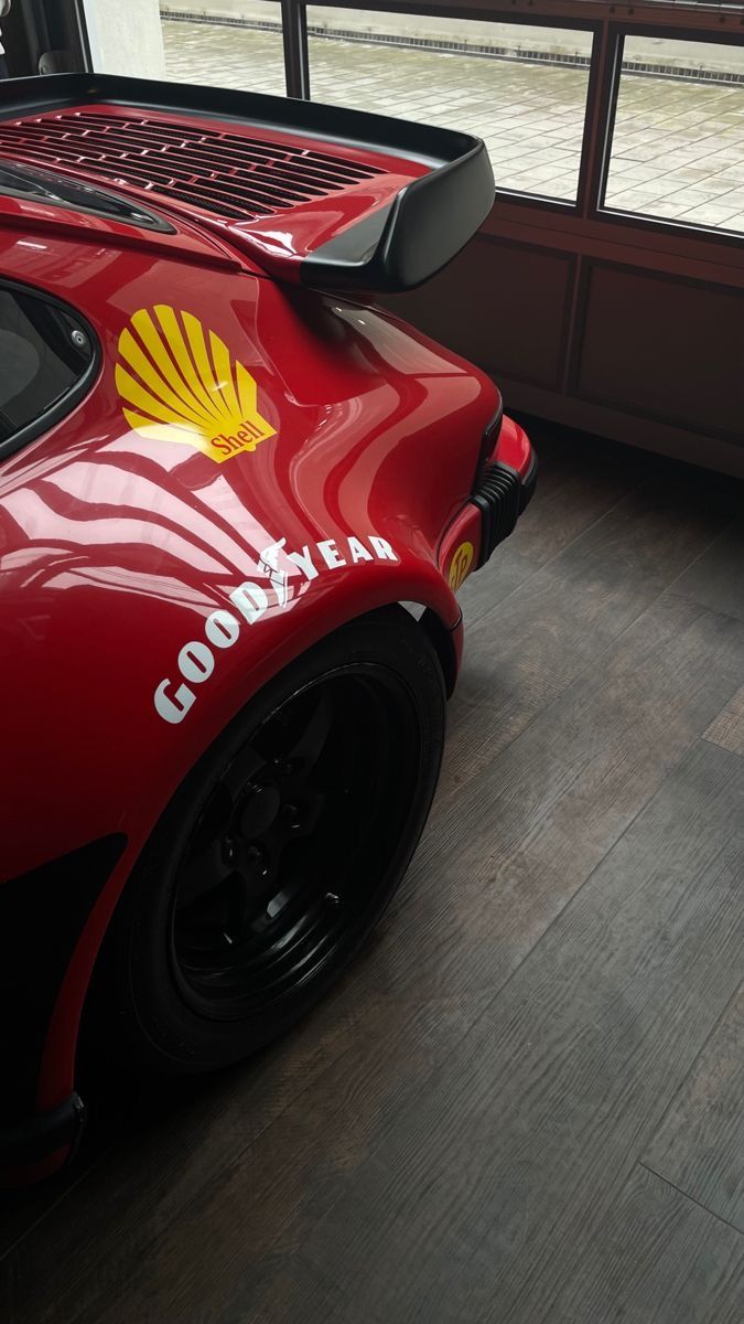 a red sports car parked in front of a window