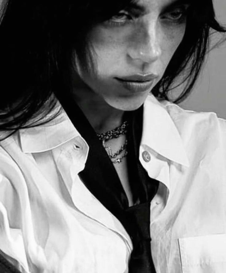 black and white photograph of a woman with long hair wearing a shirt and neck tie