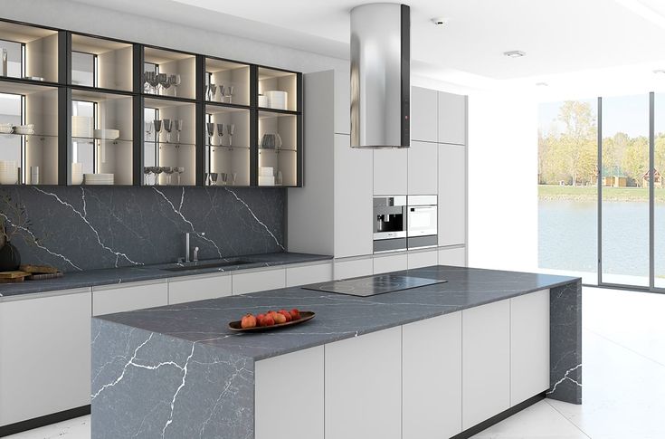 a large kitchen with marble counter tops and white cabinets