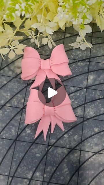 a pink bow on top of a table next to flowers