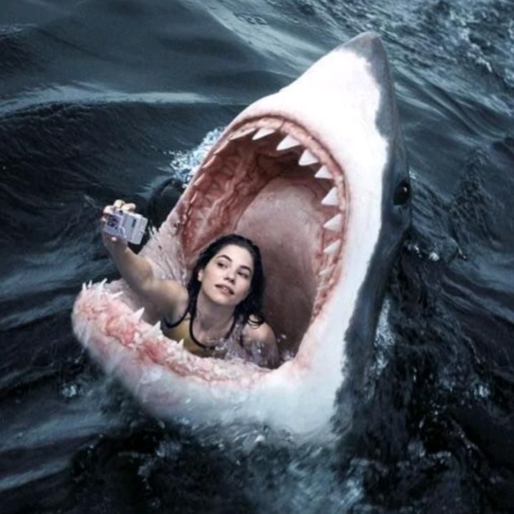 a woman in a boat with a shark's mouth open and water surrounding her