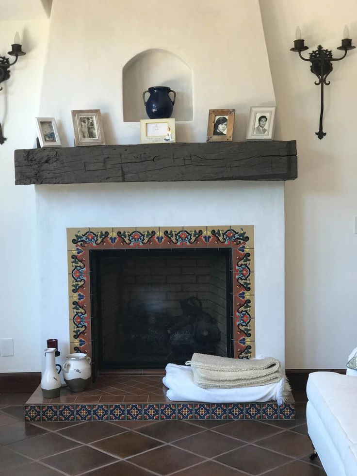 a living room with a fireplace and pictures on the mantle