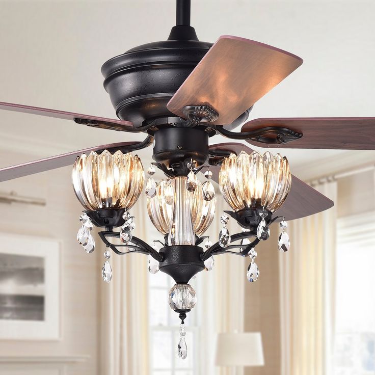 a ceiling fan with three lights hanging from it's blades in a living room