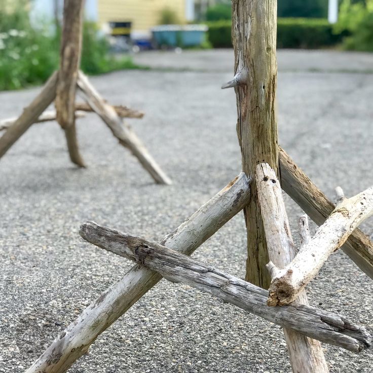 an old wooden structure with sticks sticking out of it's sides on the ground