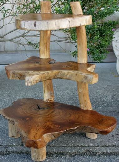 a wooden shelf sitting on top of a cement floor next to a tree branch planter