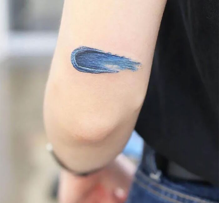 a close up of a person's arm with a blue ink stain on it