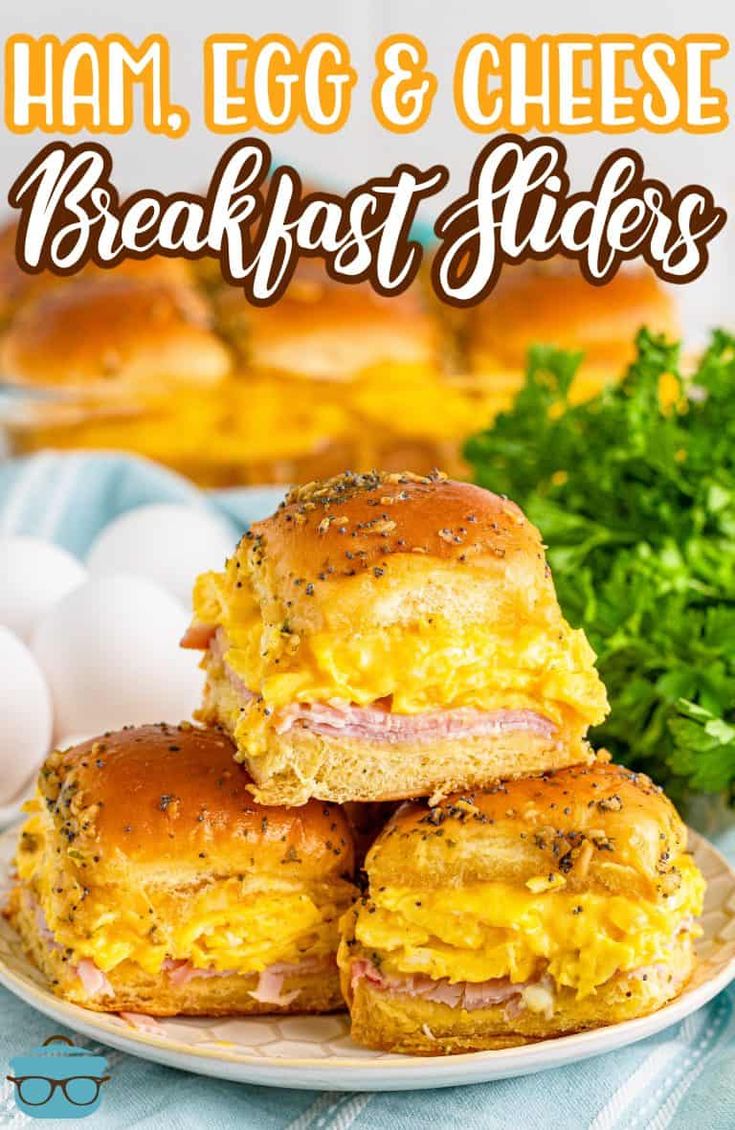 ham, egg and cheese breakfast sliders are stacked on a plate with parsley