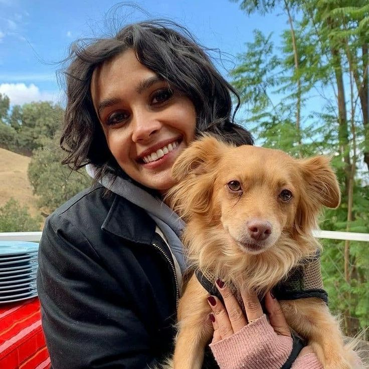 a woman holding a dog in her arms