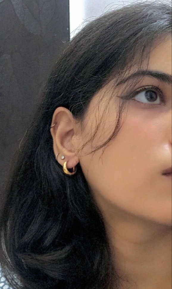 a close up of a person wearing a pair of ear piercings on their ears