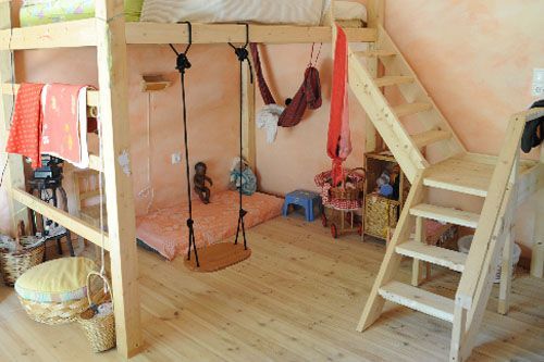 a loft bed with ladders is in the middle of a room filled with children's toys