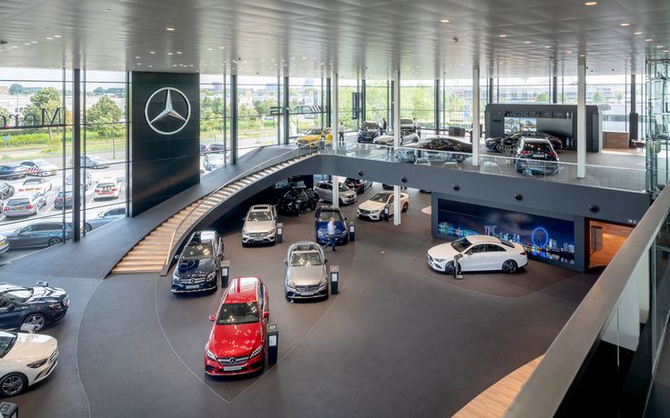 a car showroom filled with lots of different types of cars parked in front of large windows