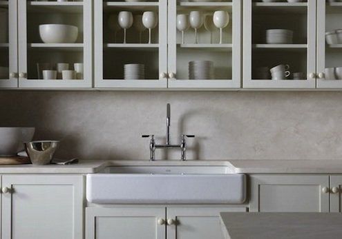 a kitchen with white cabinets and dishes in it