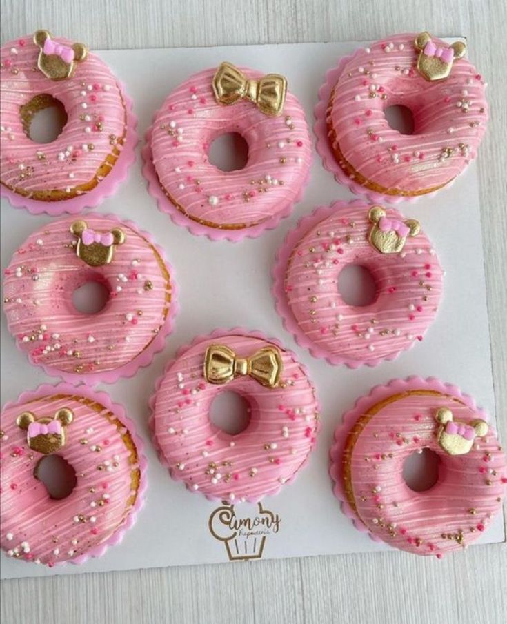 pink frosted donuts with bows and hearts on them are arranged in a pattern