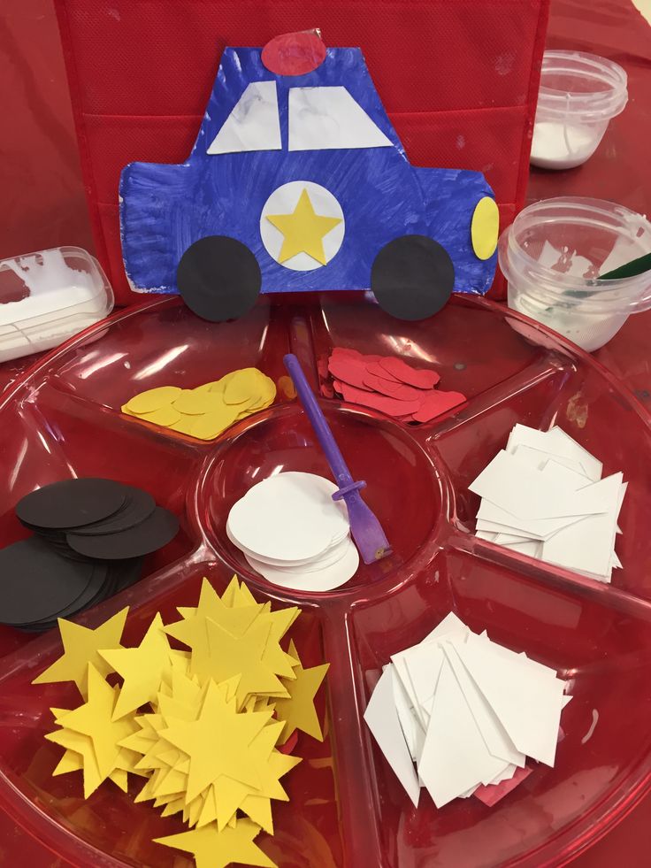 a red tray topped with lots of paper cut out shapes and stars on top of it