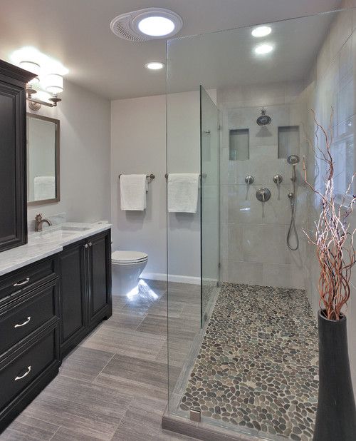 a bathroom with a large walk in shower next to a toilet and counter top sink