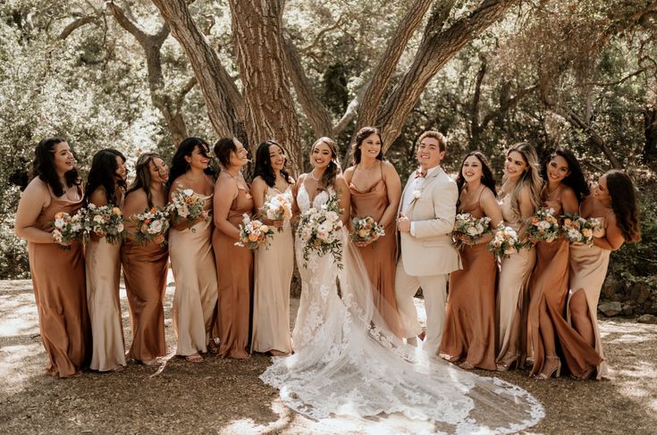 a group of women standing next to each other in front of a tree with flowers