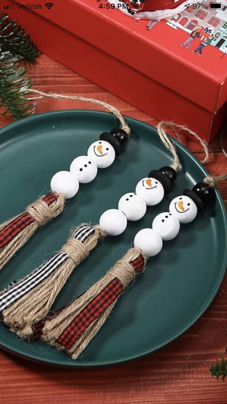 three snowman ornaments are on a green plate