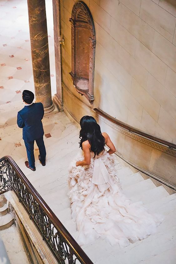 a bride and groom are walking down the stairs