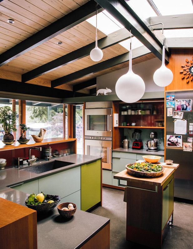 a kitchen with lots of counter space and hanging lights above the island in front of it