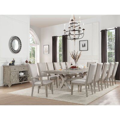 a dining room table with white chairs and a chandelier hanging from the ceiling