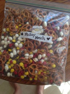 a bag filled with candy and pretzels next to a person holding it up