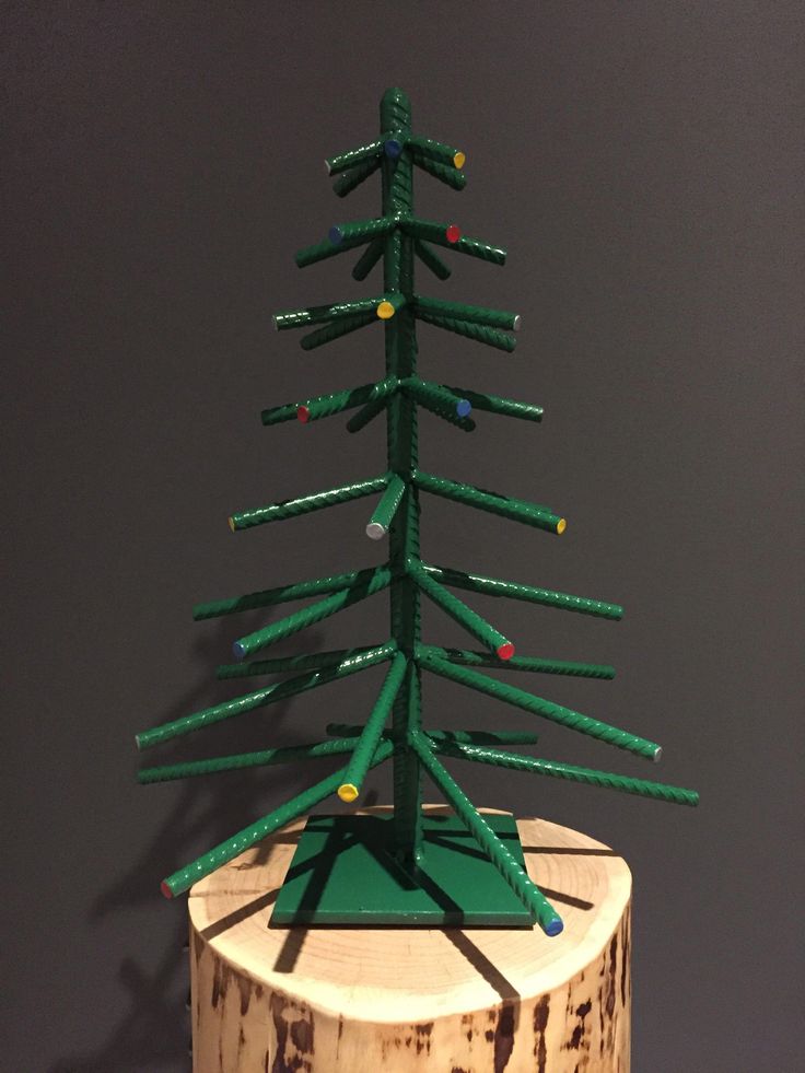 a small green christmas tree sitting on top of a wooden stump