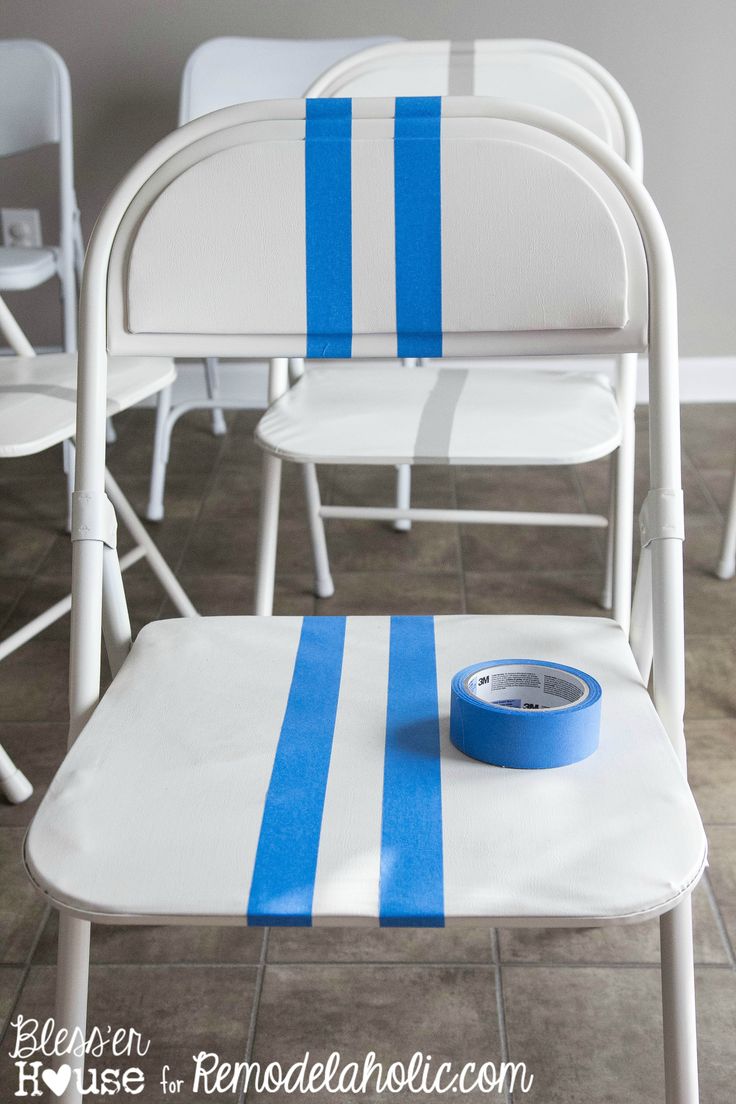 white folding chairs with blue stripes on them and a roll of tape sitting on the seat