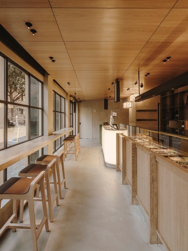 an empty restaurant with lots of counter space and stools in front of the windows