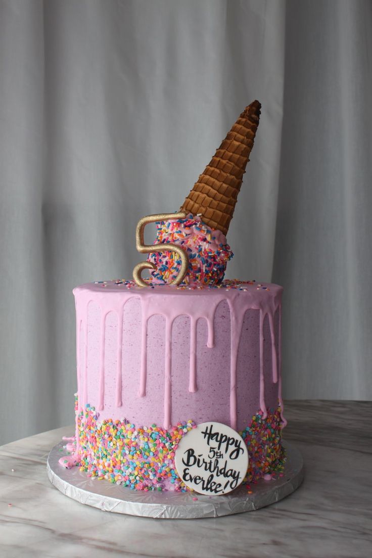 a birthday cake decorated with sprinkles and an ice cream cone