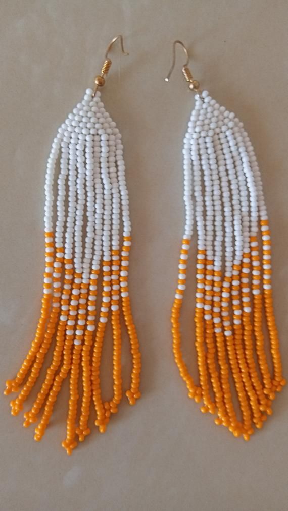 African beaded earrings, Handmade earrings, African jewelry, Maasai jewelry, Earrings for women,Gift for her, Tribal EarringsThese stunning earring are superbly crafted which will absolutely makes stand out in any occasion.Color - White and Orange.3-5 days delivery via DHL ExpressThe shipping fee is for the first item only and additional necklaces or items ship for free.Wholesale available at a fair price,please contact me.For any clarification,please send me a convo or an e-mail.Thank you for v White Earrings With Latkans For Festivals, White Latkans Earrings For Festivals, White Latkans Earrings, White Drop Chandelier Earrings For Festivals, Traditional White Beaded Earrings With Ear Wire, White Beaded Earrings For Festivals Gift, White Beaded Earrings For Festivals And Gifts, Festival White Earrings With Latkans, Traditional White Dangle Chandelier Earrings