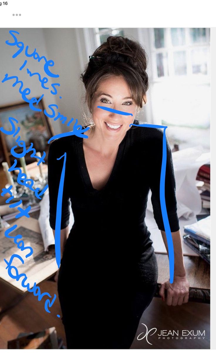 a woman in a black dress with blue writing on her face and hands behind her back