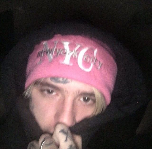 a young man wearing a pink beanie hat