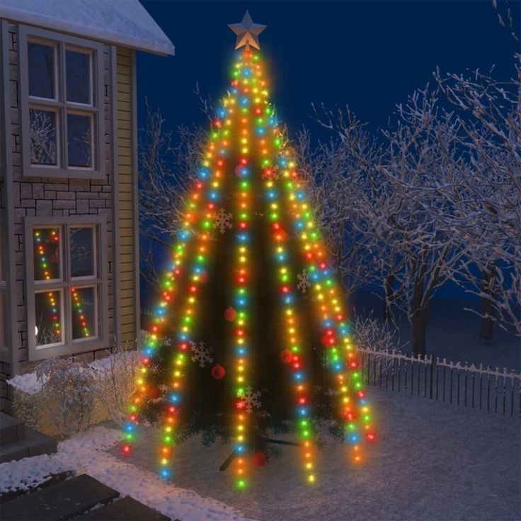 a lighted christmas tree in front of a house