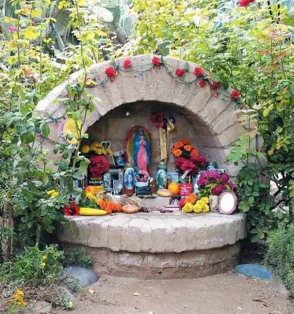 an outdoor shrine surrounded by flowers and plants