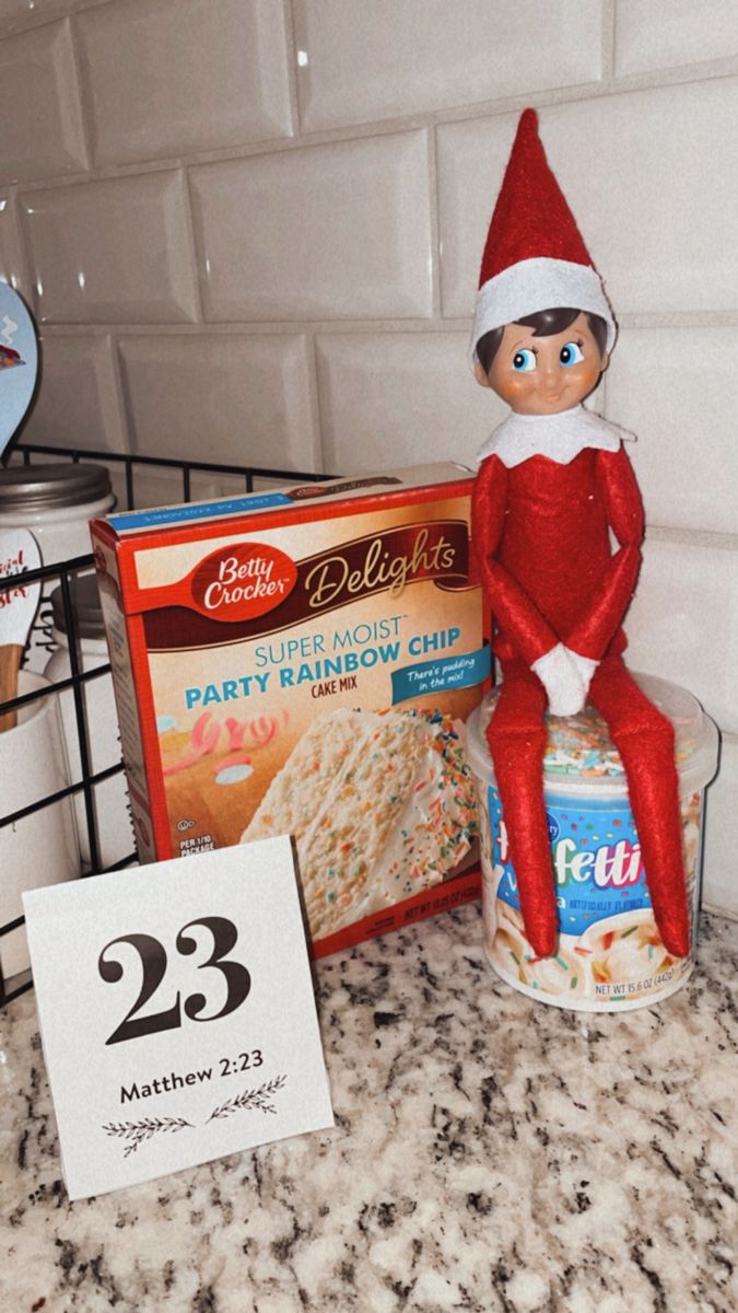 an elf sitting on top of a box of cereal next to a package of cake mix