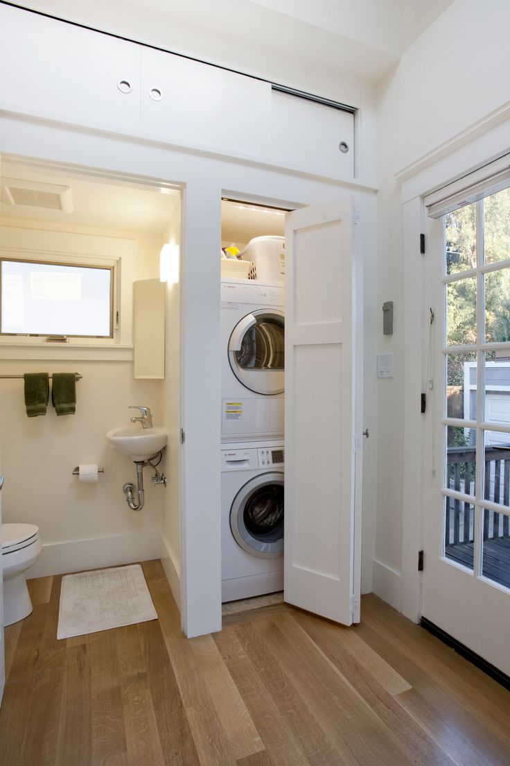 a washer and dryer in a small room next to a door that leads into a bathroom