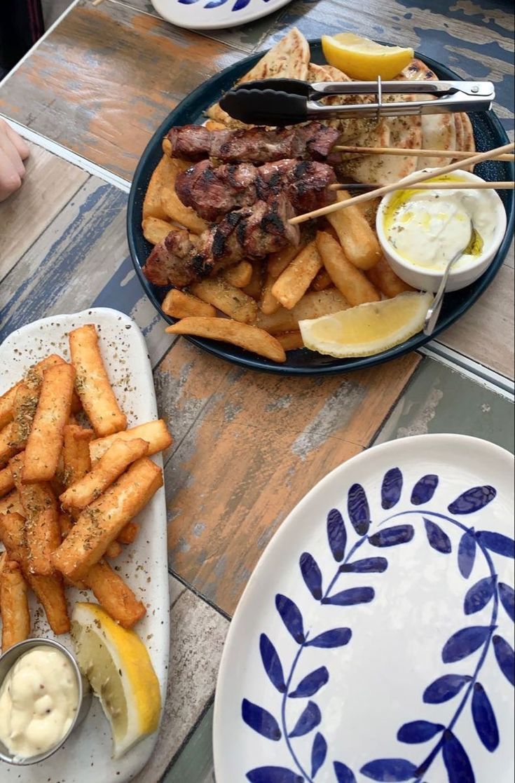 two plates filled with food sitting on top of a table next to another plate full of food