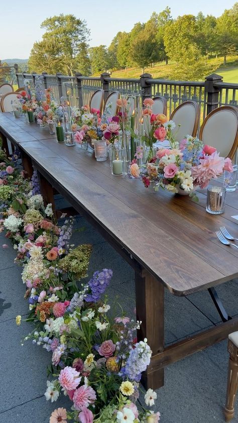 a long wooden table topped with lots of flowers