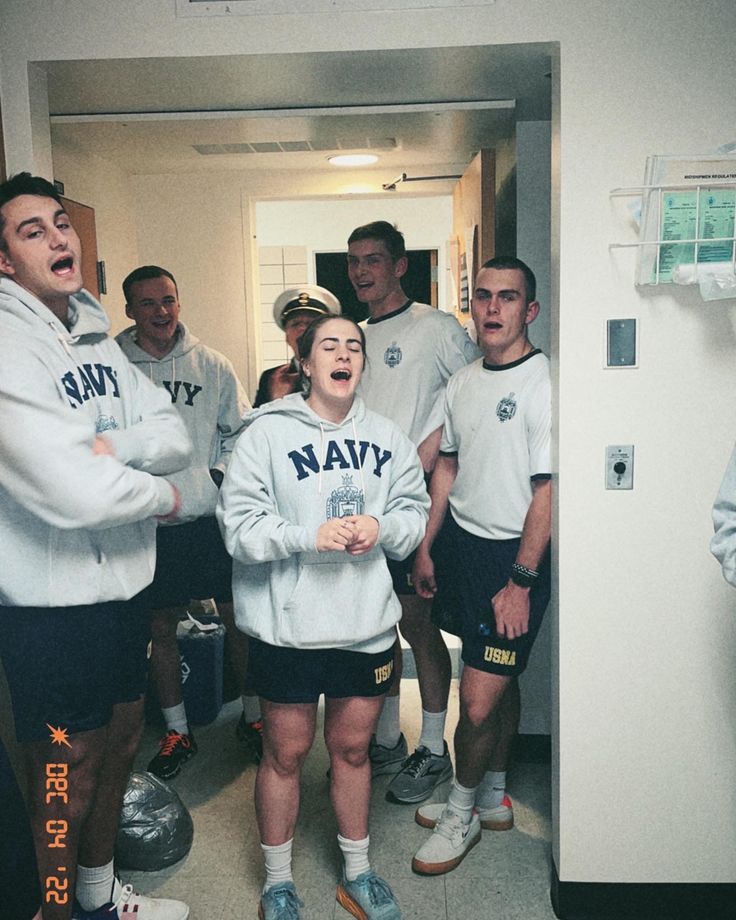 a group of young men standing next to each other in front of a locker room