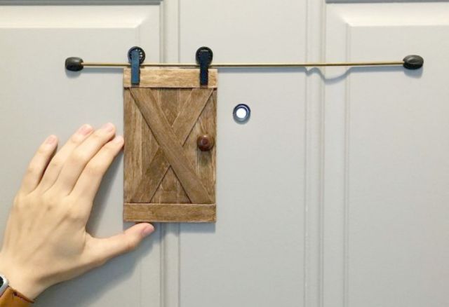 a person's hand reaching for a piece of wood hanging on a clothes line