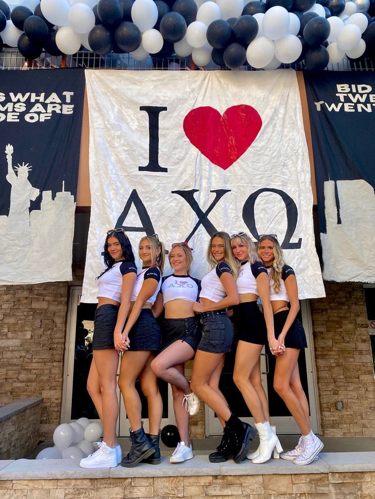 the girls are posing in front of an i love axo banner