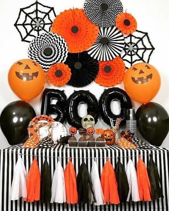 a table topped with halloween decorations and balloons