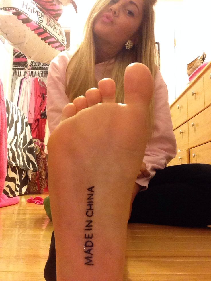 a woman sitting on the floor with her foot up in front of her face and words written on it